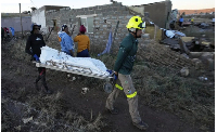 A photo of rescue workers transporting a person in a body bag after floods in Mthatha, South Africa