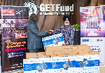 GetFund Administrator Paul Adjei receiving the item from IPMC's Amar Deep Singh Hari (R)