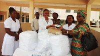 Dr. Osa Olayemi, the Acting Head of the Korle Bu Polyclinic (2nd from left), receiving the items fro