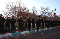 Members of the Iranian police stand guard at a protest in front of the British embassy