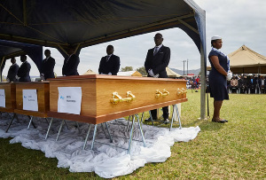 Pallbearers stand guard overlooking coffins during a memorial service held for the victims