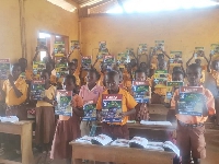 Basic school pupils showing the textbooks they received