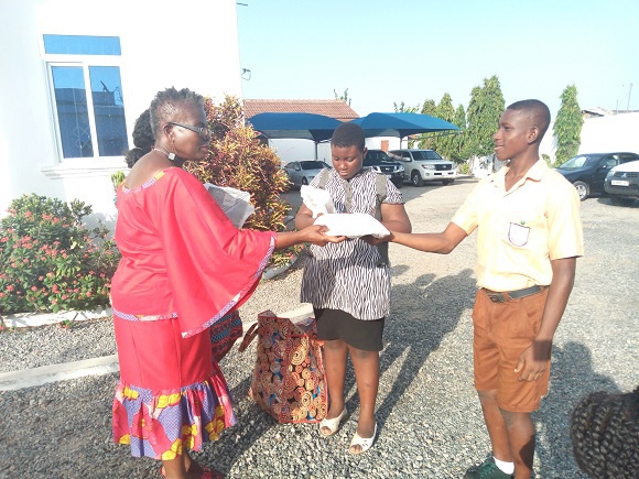 Founder of Maa Sankofa Foundation, Adjo Palmer presenting items to some students