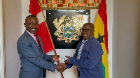 Prof. Ken Attafuah (right) presenting the Ghana Card to a staff at the Ghana Embassy in Denmark