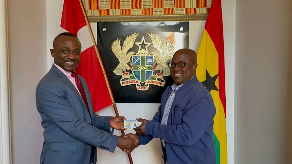 Prof. Ken Attafuah (right) presenting the Ghana Card to a staff at the Ghana Embassy in Denmark