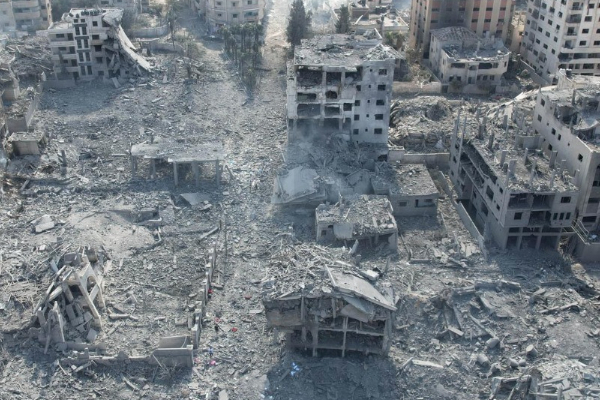 A photo of collapsed buildings, smoke and debris filling the streets