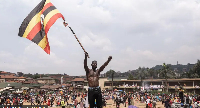 Supporter of Bobi Wine carry di Uganda flag for di party final campaign rally