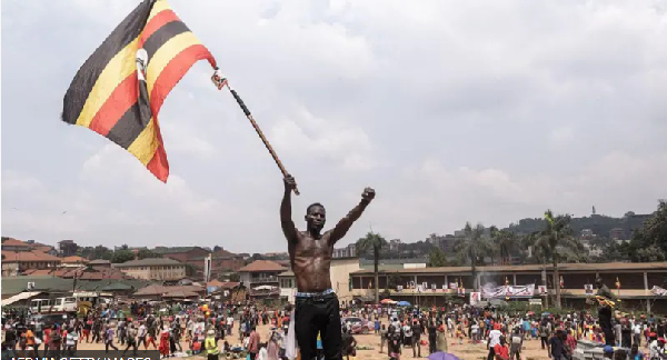 Supporter of Bobi Wine carry di Uganda flag for di party final campaign rally