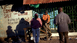 Gambians sit in the sun in Serrekunda, Gambia