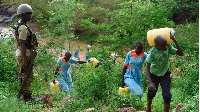A policeman watches over as pupils fetch water in the banditry hit North Rift region on May 11, 2023