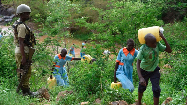 A policeman watches over as pupils fetch water in the banditry hit North Rift region on May 11, 2023