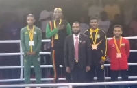 Patrick 'Baddo' Chinyemba, Zambian gold medalist with hand on chest during award ceremony