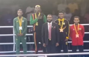 Patrick 'Baddo' Chinyemba, Zambian gold medalist with hand on chest during award ceremony
