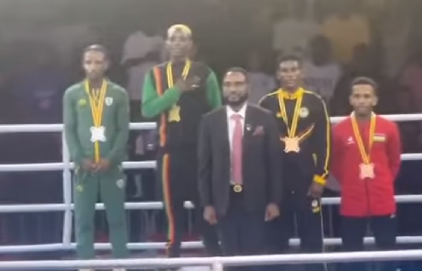 Patrick 'Baddo' Chinyemba, Zambian gold medalist with hand on chest during award ceremony