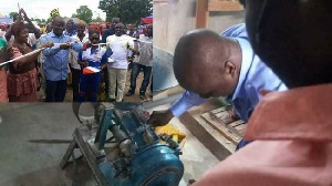 Samuel Abu Jinapor cutting the sod and also inspecting the grinding mills