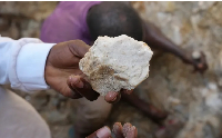 A man shows lithium stone from an illegal mining site in Paseli, north-central Nigeria