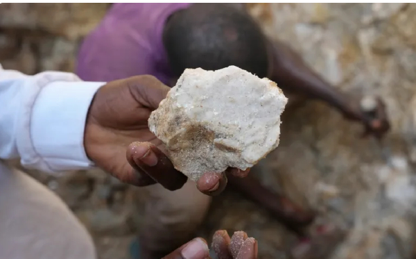 A man shows lithium stone from an illegal mining site in Paseli, north-central Nigeria