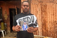 Victor Dennis holds a cherished photo of his son, Emmanuel