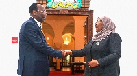 Chairman of the Chadema opposition party Freeman Mbowe (L) shakes hands with President Samia Suluhu