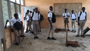 Some of the students leaning against the classroom walls