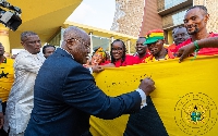 Akufo Addo signs on a giant Ghana flag after meeting supporters