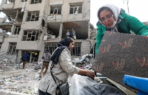 Family members gather their belongings after an air strike on an apartment block in Tehran, Iran