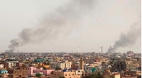 Smoke billows behind buildings in Khartoum, as fighting between Sudan's warring generals intensified