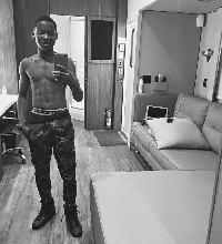 Abraham Attah seen in camouflage khaki trousers, with his abs in full display