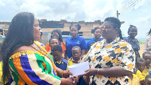 Catherine Onwah (R) making the presentation to the school representative
