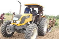 Dr Afriyie Akoto ploughing the Nsawam prisons farmland with some senior officers