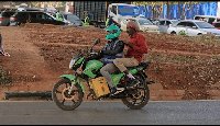 Men ride an electric motorcycle in Nairobi, Kenya