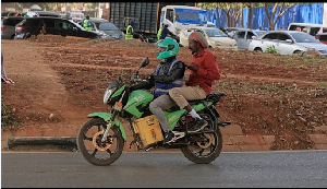 Men ride an electric motorcycle in Nairobi, Kenya