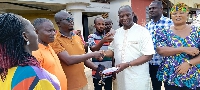 Emmanuel Armah Kofi Buah gives an envelope to the people of Nkroful