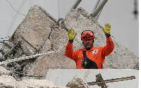 A rescue worker gestures while searching through rubble two days after an earthquake struck Cali