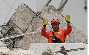 A rescue worker gestures while searching through rubble two days after an earthquake struck Cali