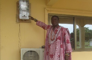 Nene Atiapa III pointing to the meter in his palace