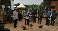 Dr. Alfred Sugri Tia holding the pick axe at at the sodcutting ceremony supported by Nii Osah Mills