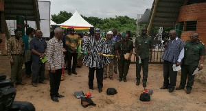 Dr. Alfred Sugri Tia holding the pick axe at at the sodcutting ceremony supported by Nii Osah Mills