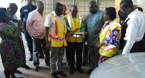 Titus Glover (middle) checking one of the fake documents with the officials of the DVLA