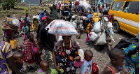 Congolese people carry their belongings as they flee from their villages