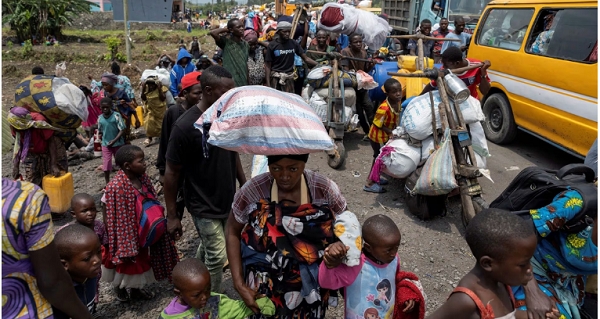 Congolese people carry their belongings as they flee from their villages
