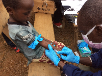A healthcare professional injecting  a child