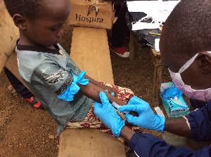 A healthcare professional injecting  a child