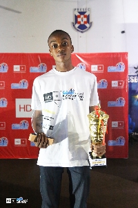A winner holding a plaque and a trophy