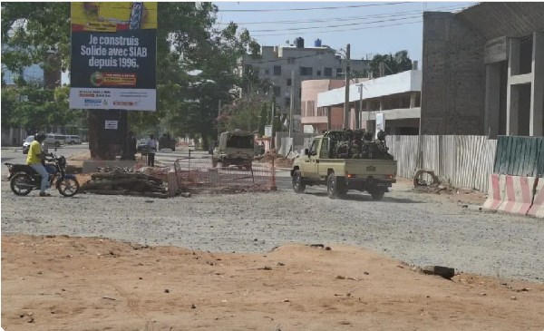 Soldiers ride in a military vehicle along a street amid an attempted coup in Cotonou, Benin