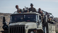 Members of the armed forces ride a military vehicle as fighting across Ethiopia intensifies