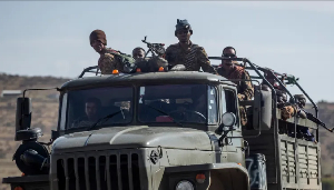 Members of the armed forces ride a military vehicle as fighting across Ethiopia intensifies