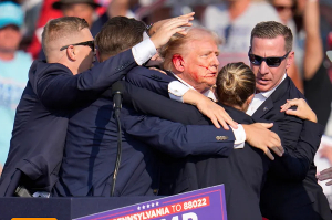 Secret Service agents swiftly moved to shield Trump and escort him off the stage