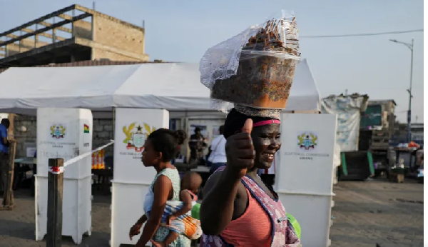People walk past a polling station on the day of Ghana's presidential and parliamentary elections