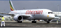 A ground crew member guides an Ethiopian Airlines  at Bole International Airport